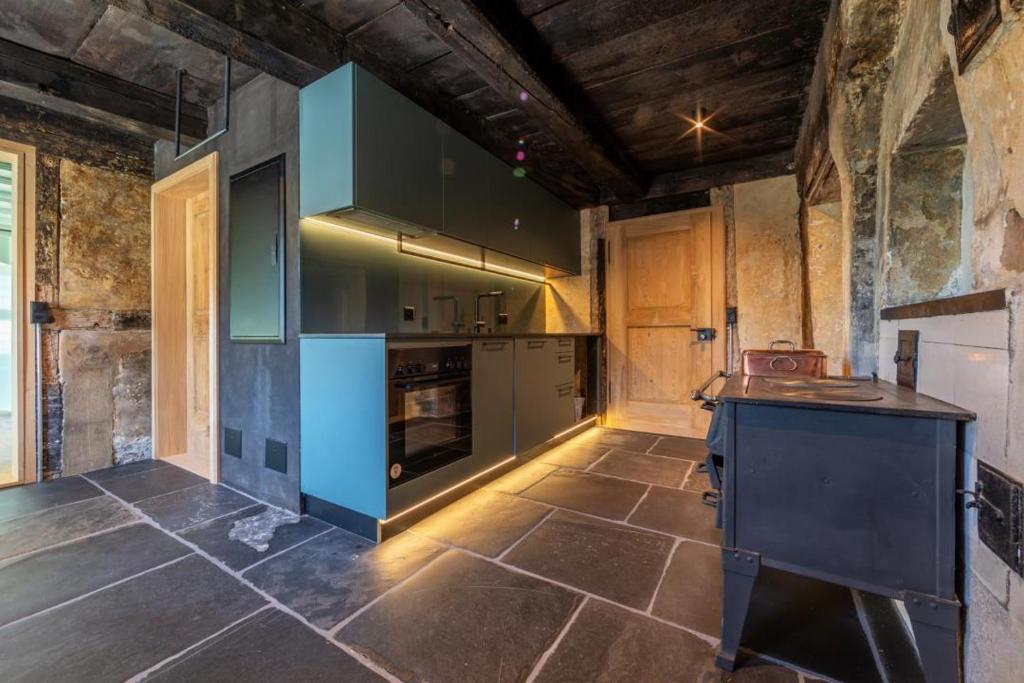 uma cozinha com uma ilha azul num quarto em Revier Baudenkmal Beuge em Näfels