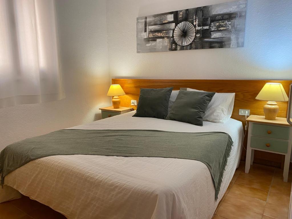 sypialnia z dużym łóżkiem z 2 stolikami nocnymi i 2 lampami w obiekcie Apartamento renovado en Puerto de la Cruz w Puerto de la Cruz