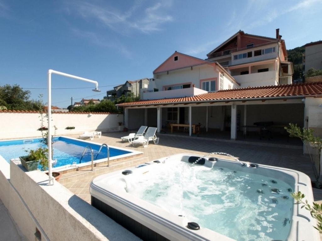 a hot tub on a patio next to a house at Apartments and rooms with a swimming pool Kali, Ugljan - 14083 in Kali