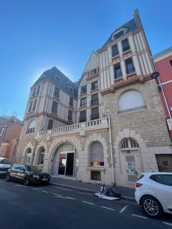 un grand bâtiment avec des voitures garées devant lui dans l'établissement Hyper centre idéal gare Amiens, à Amiens