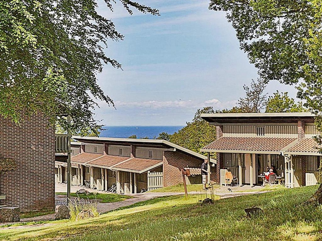 a group of buildings with the ocean in the background at 7 person holiday home in Allinge in Allinge