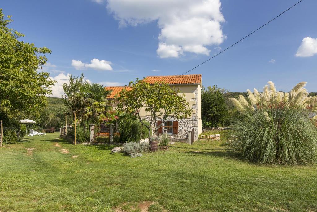 een klein huis in een tuin met een groen veld bij Holiday house with a parking space Mali Turini (Central Istria - Sredisnja Istra) - 14136 in Labin