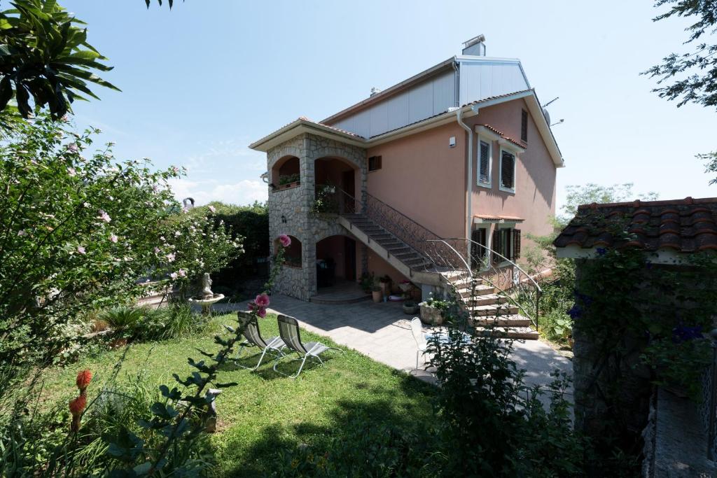 a house with a staircase and a grass yard at Apartments with a parking space Icici, Opatija - 14155 in Ičići