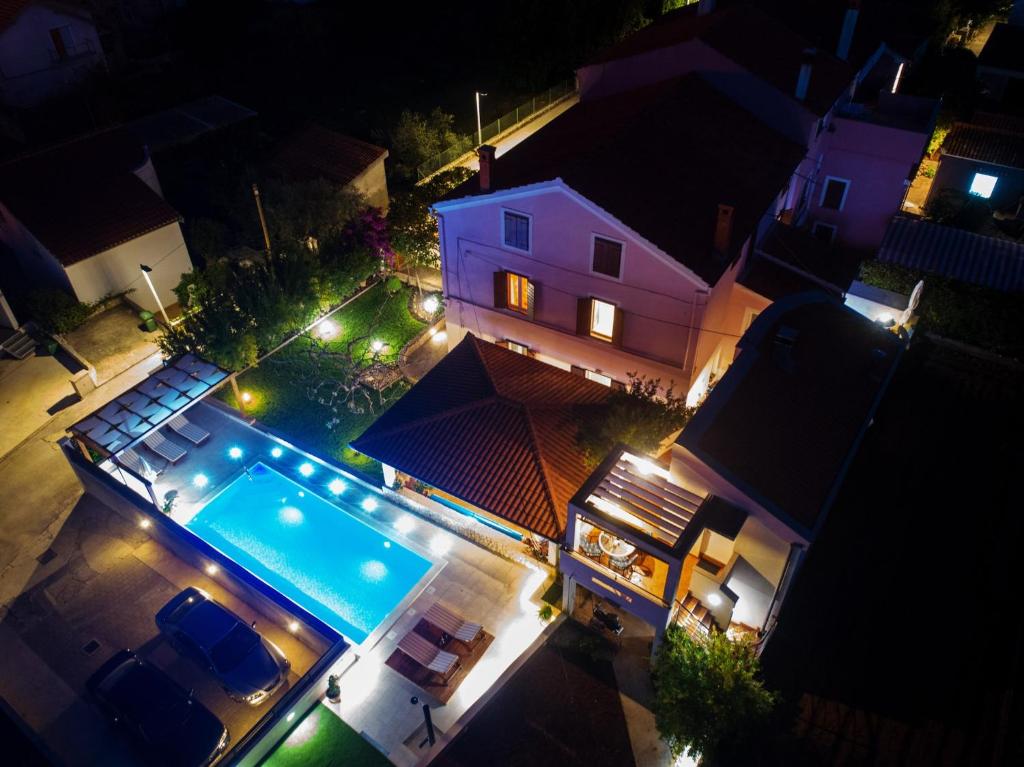 uma vista superior de uma casa com uma piscina à noite em Apartments with a swimming pool Preko, Ugljan - 14163 em Preko