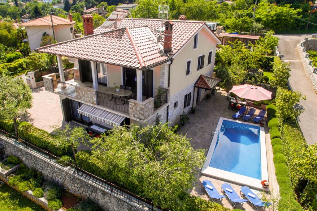 - une vue aérienne sur une maison avec une piscine dans l'établissement Apartments with a swimming pool Lovran, Opatija - 14196, à Lovran