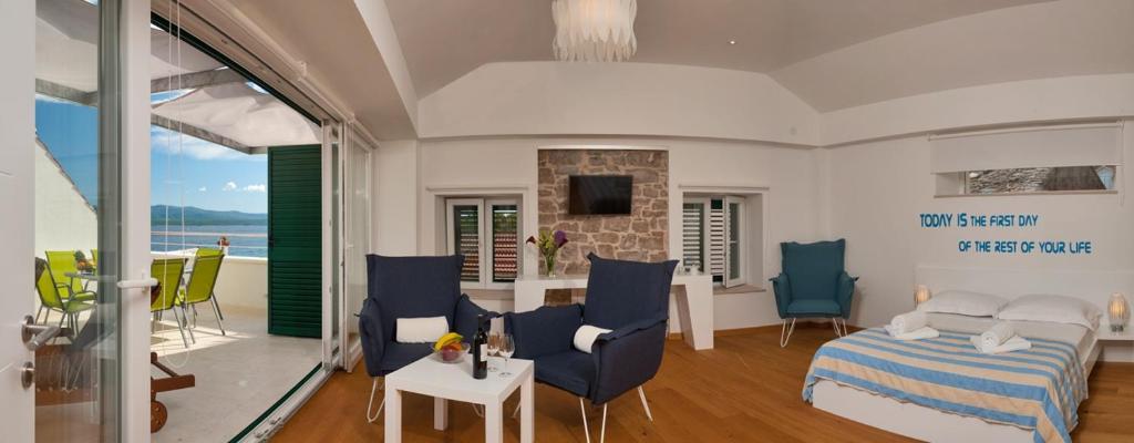 ボルにあるSeaside family friendly house with a swimming pool Bol, Brac - 14239のベッドとテーブルと椅子のあるリビングルーム