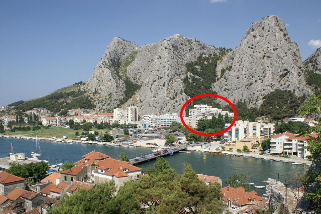 a view of a town next to a river with mountains at Apartments with a parking space Omis - 14290 in Omiš