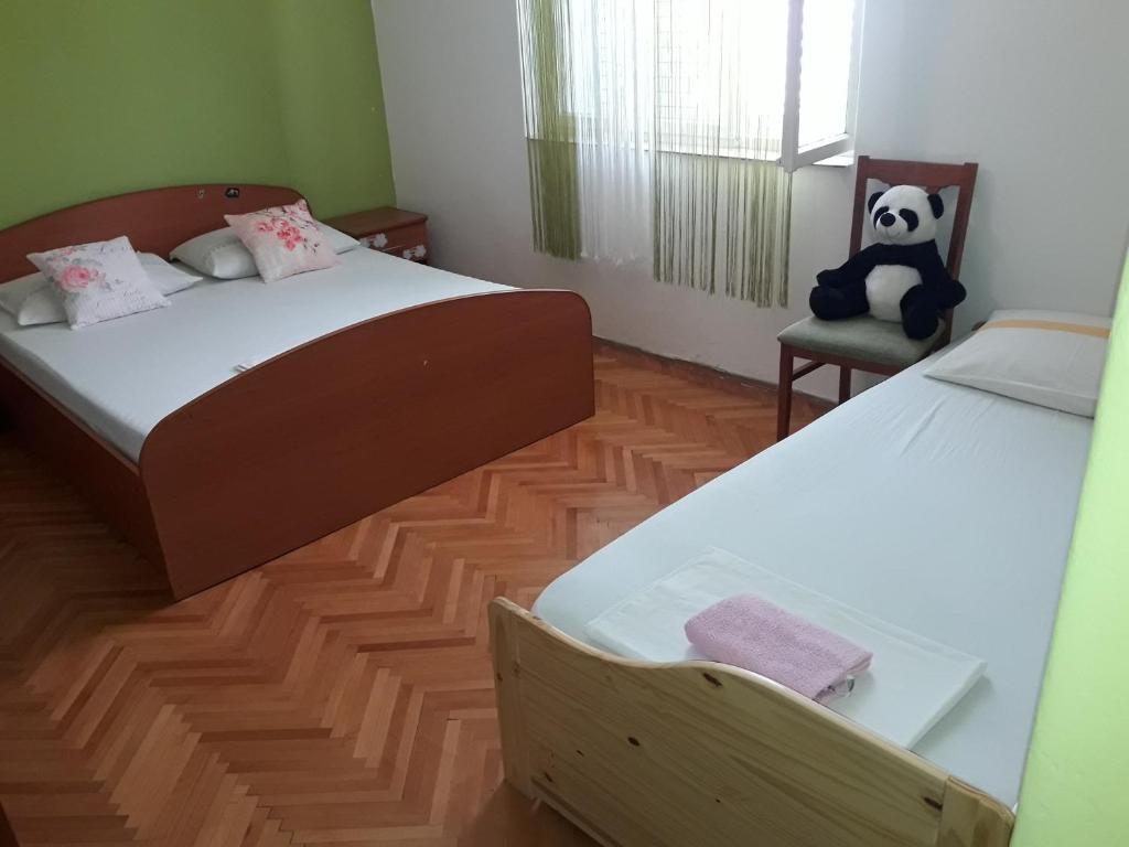 ein Schlafzimmer mit 2 Betten und einem gefüllten Panda-Bär auf einem Stuhl in der Unterkunft Apartments by the sea Trpanj, Peljesac - 14309 in Trpanj