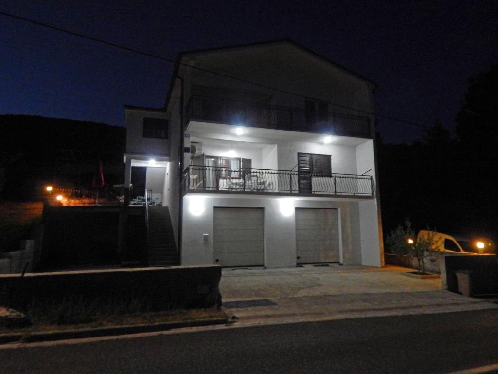 Casa blanca con balcón por la noche en Apartments with a parking space Tugare, Omis - 14320, en Tugare