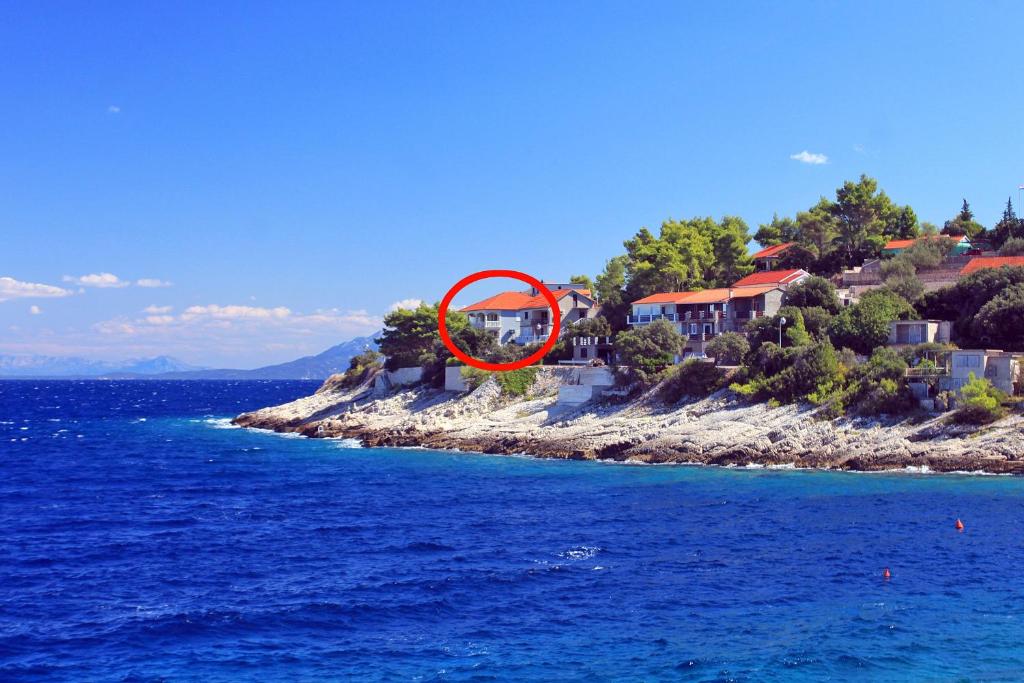 dom na wyspie w oceanie z czerwonym krągiem w obiekcie Apartments by the sea Prigradica, Korcula - 14341 w mieście Blato