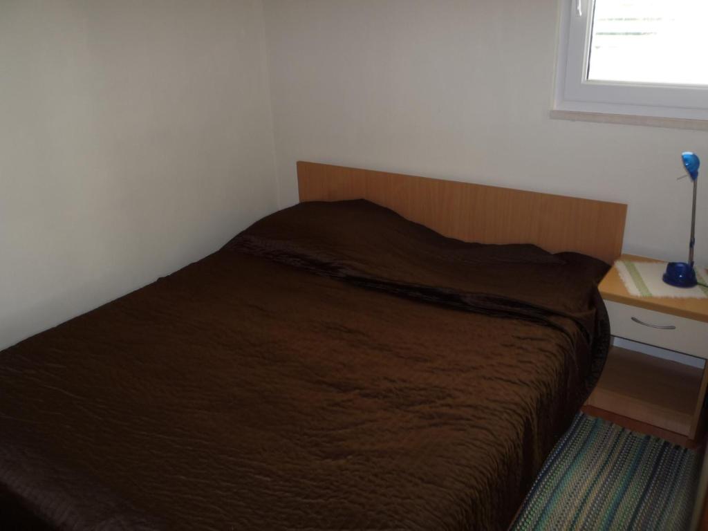 a bed with a wooden headboard in a bedroom at Apartments with a parking space Savar, Dugi otok - 14373 in Savar