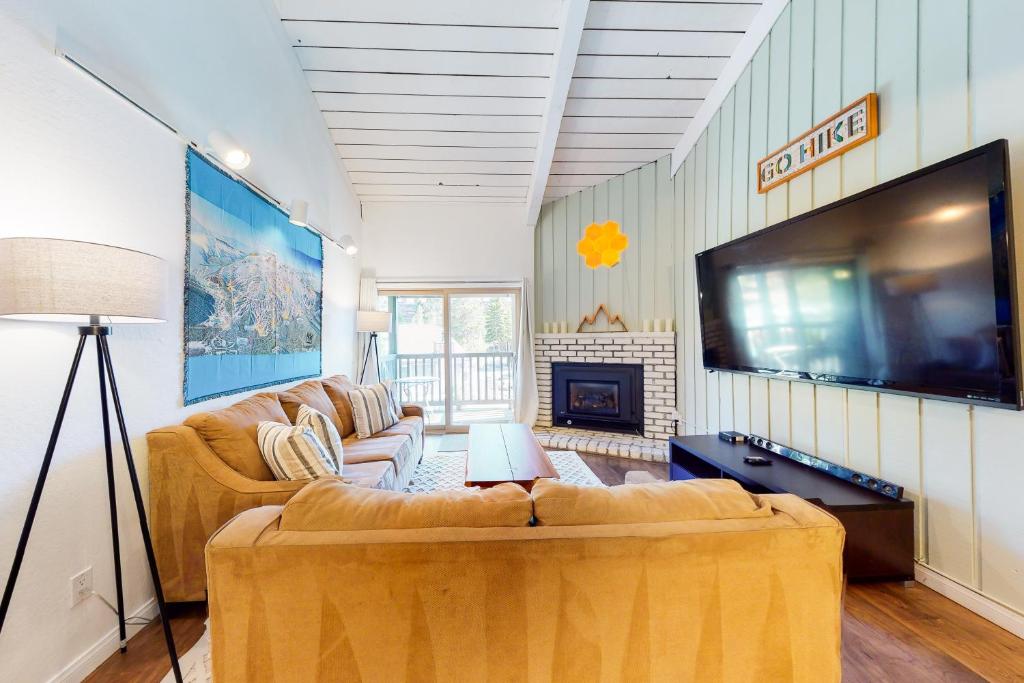 a living room with two couches and a flat screen tv at Chamonix 20 in Mammoth Lakes