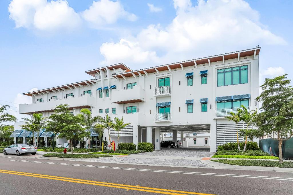 a white building with a car parked in front of it at SoCe Flats 209 in Naples