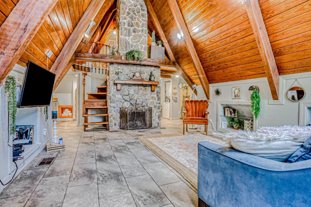a living room with a stone fireplace and wooden ceilings at Woodland Garden in Tampa