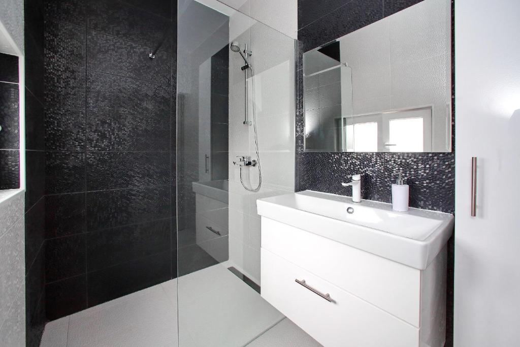W łazience znajduje się biała umywalka i prysznic. w obiekcie Apartments with a parking space Bibinje, Zadar - 14436 w Bibinje