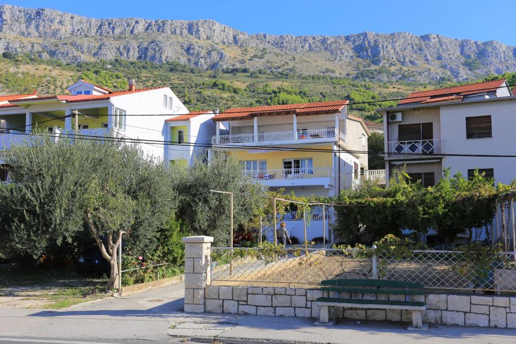 una fila de casas con montañas en el fondo en Apartments by the sea Sumpetar, Omis - 14450 en Jesenice