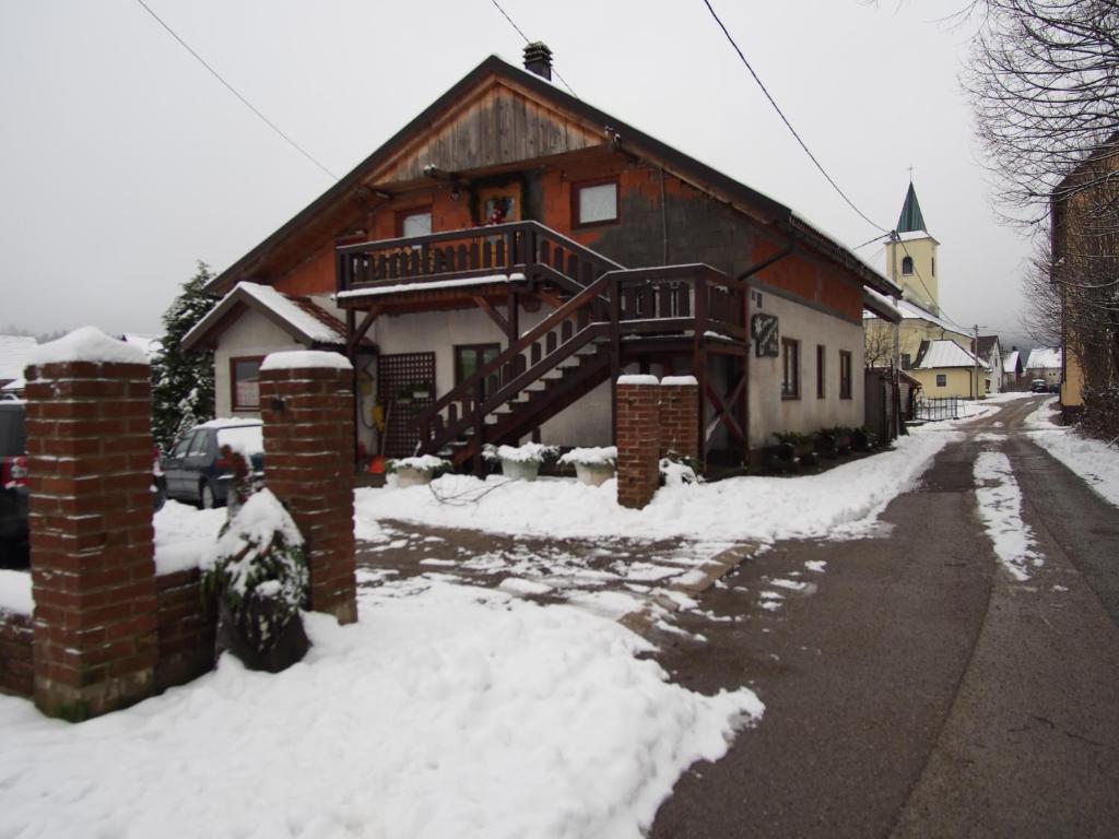 a house with a wooden staircase in the snow at Apartments with a parking space Lokve, Gorski kotar - 14469 in Lokve