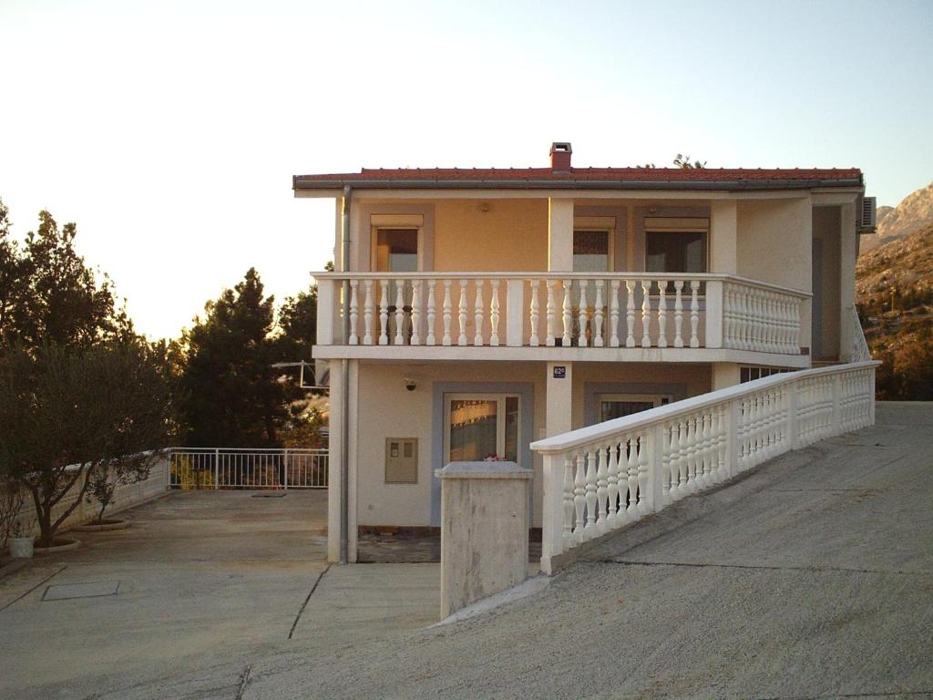 a large house with a balcony on a driveway at Apartments with a parking space Starigrad, Paklenica - 14507 in Starigrad-Paklenica