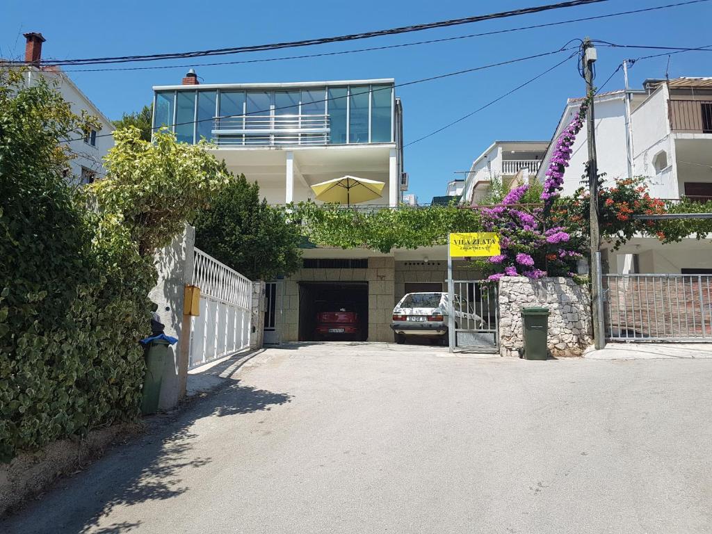 a building with a garage with a car parked in it at Apartments by the sea Marina, Trogir - 14191 in Marina