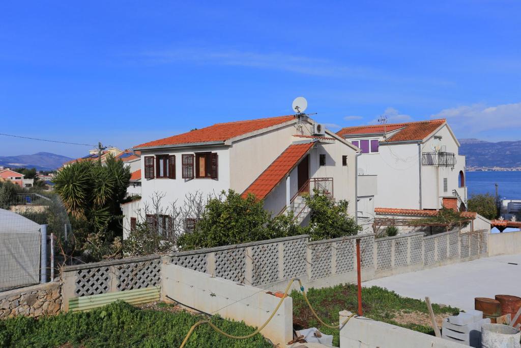 a white house with a fence in front of it at Apartments by the sea Slatine, Ciovo - 16345 in Slatine