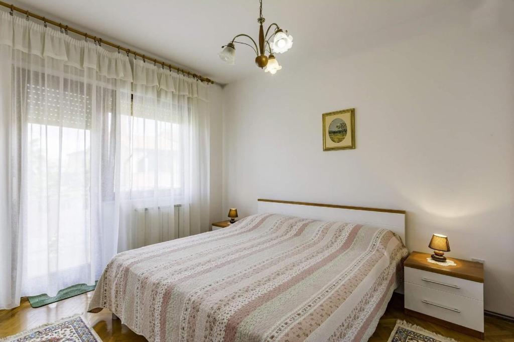 biała sypialnia z łóżkiem i oknem w obiekcie Apartments with a parking space Umag - 16354 w mieście Umag