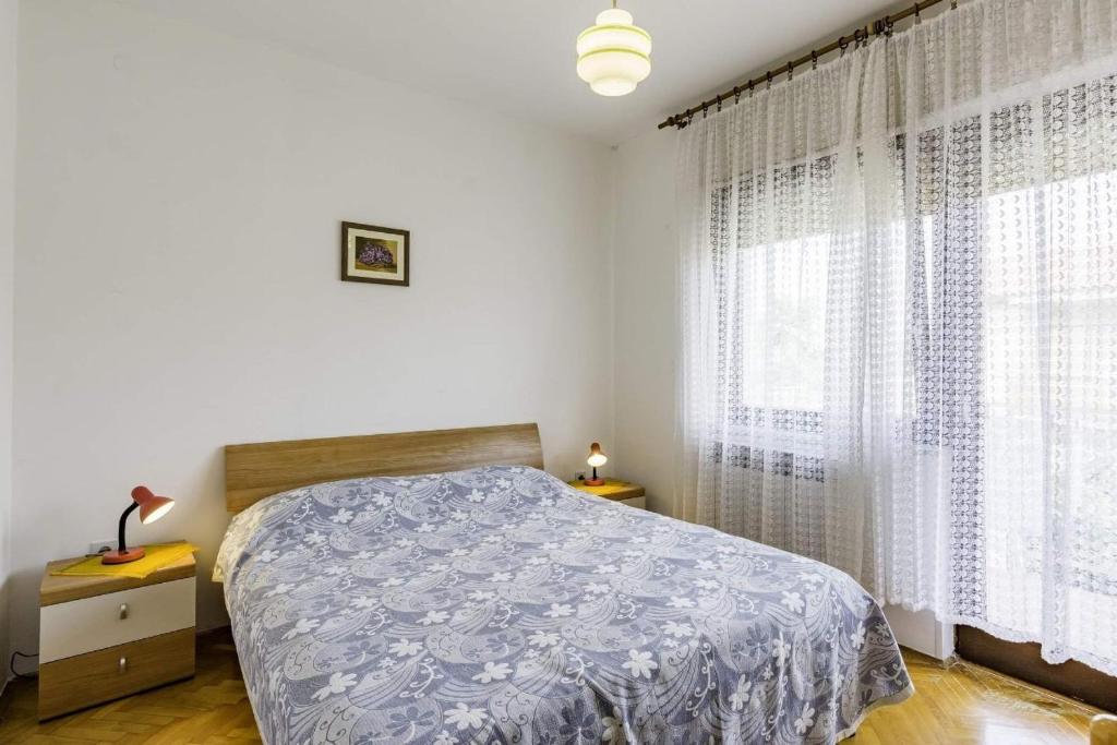 - une chambre avec un lit et une grande fenêtre dans l'établissement Apartments with a parking space Umag - 16354, à Umag