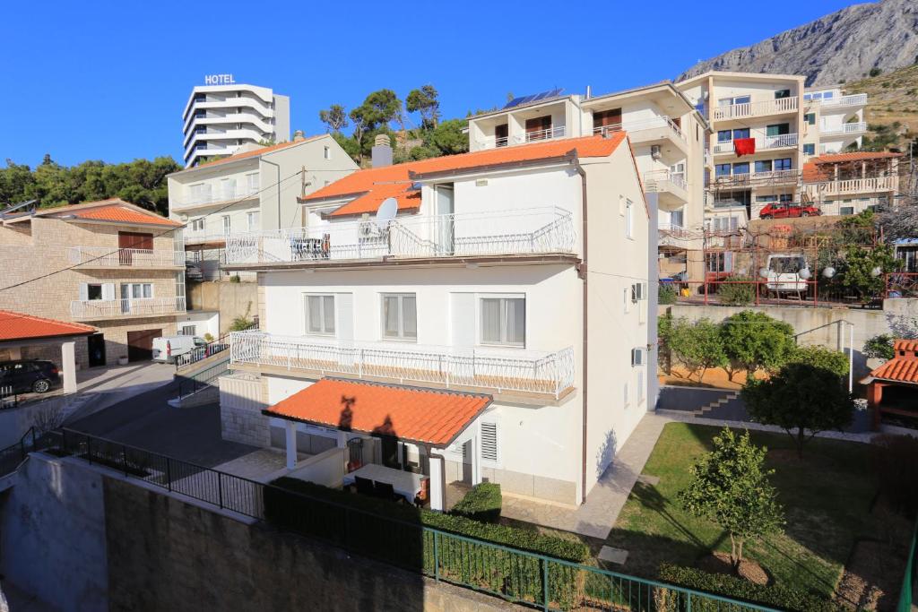 een wit huis met een oranje dak bij Apartments by the sea Duce, Omis - 16406 in Duće