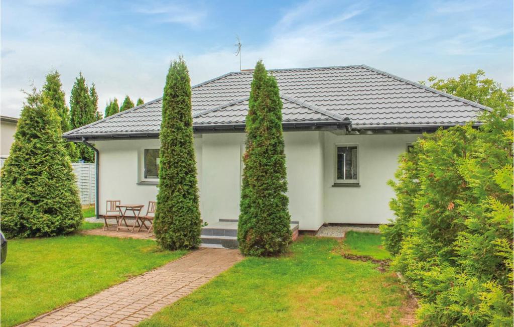 a white house with trees in front of it at Nice Home In Nowe Warpno With 2 Bedrooms And Wifi in Karszno