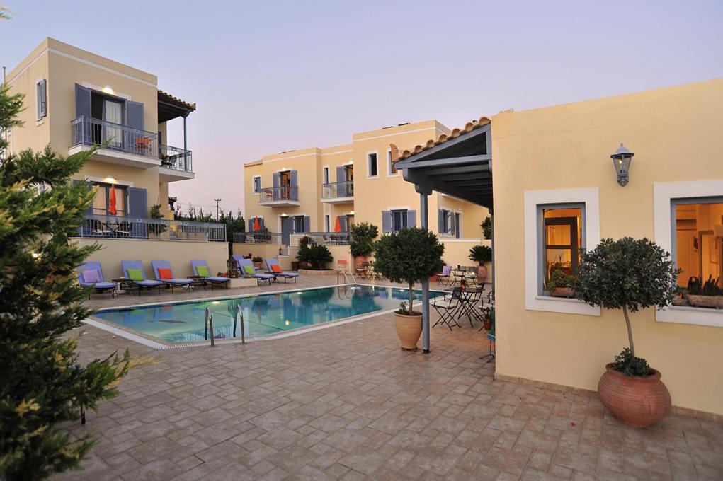 un cortile con piscina in un edificio di Fistikies Holiday Apartments a Città di Egina