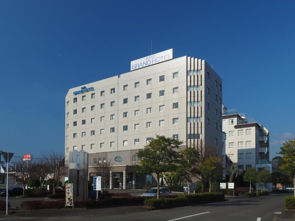 um edifício branco com uma placa em cima em Imari Grand Hotel em Imari