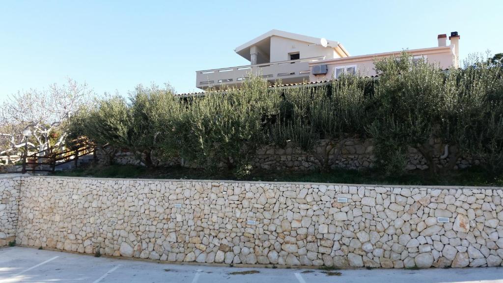 un mur en pierre devant une maison dans l'établissement Apartments with a parking space Kolan, Pag - 16482, à Kolan