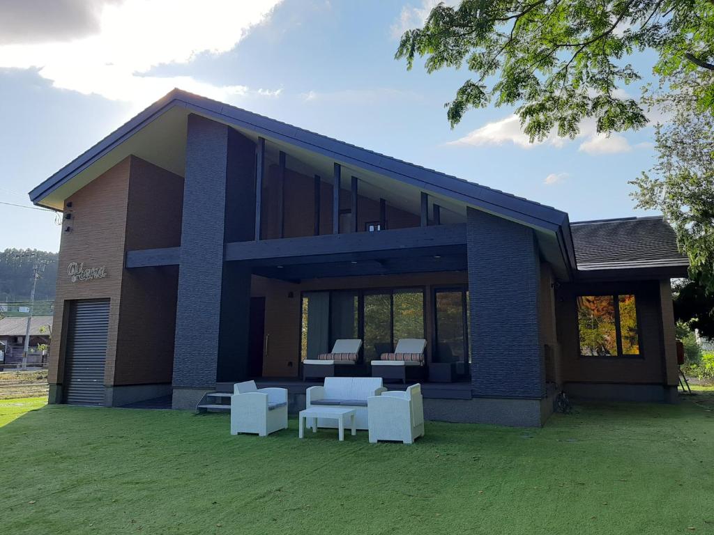 a blue house with white furniture in front of it at HANA TOYA in Lake Toya