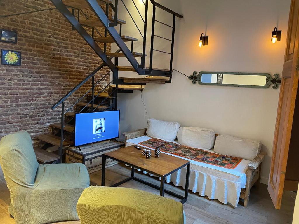 a living room with a couch and a table with a tv at LOFT centrico 11 de Abril in Bahía Blanca