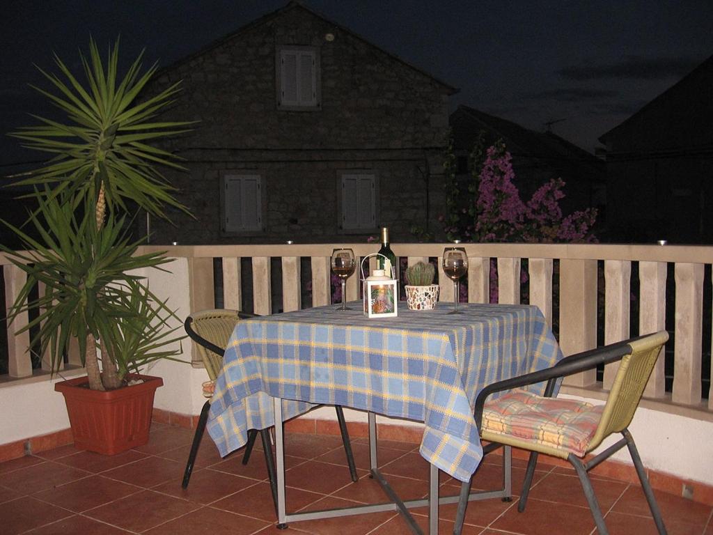 a table with two chairs and a bottle of wine at Apartment Sucuraj 16404b in Sućuraj