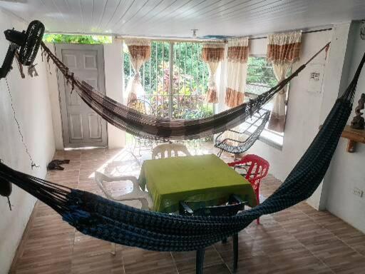 uma rede num quarto com mesa e cadeiras em ApartaRefugio EL RETIRO VERDE 2 em Letícia