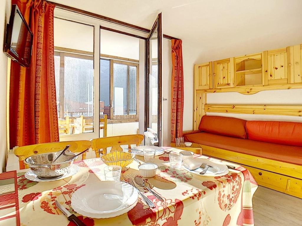 un salon avec une table et un lit dans l'établissement Studio lumineux skis aux pieds avec balcon et WIFI - FR-1-344-902, aux Menuires