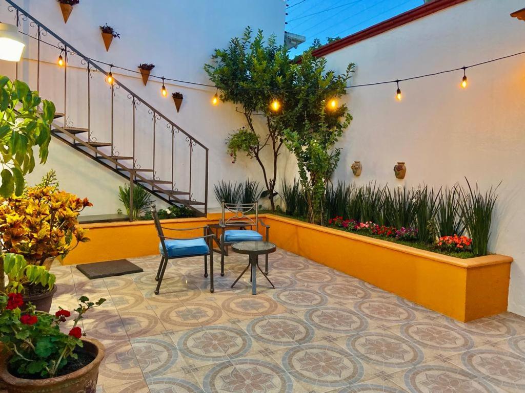 un patio con tavolo, sedie e piante di Iluminada y confortable habitaciones en Casa Margarita Oaxaca a Città di Oaxaca