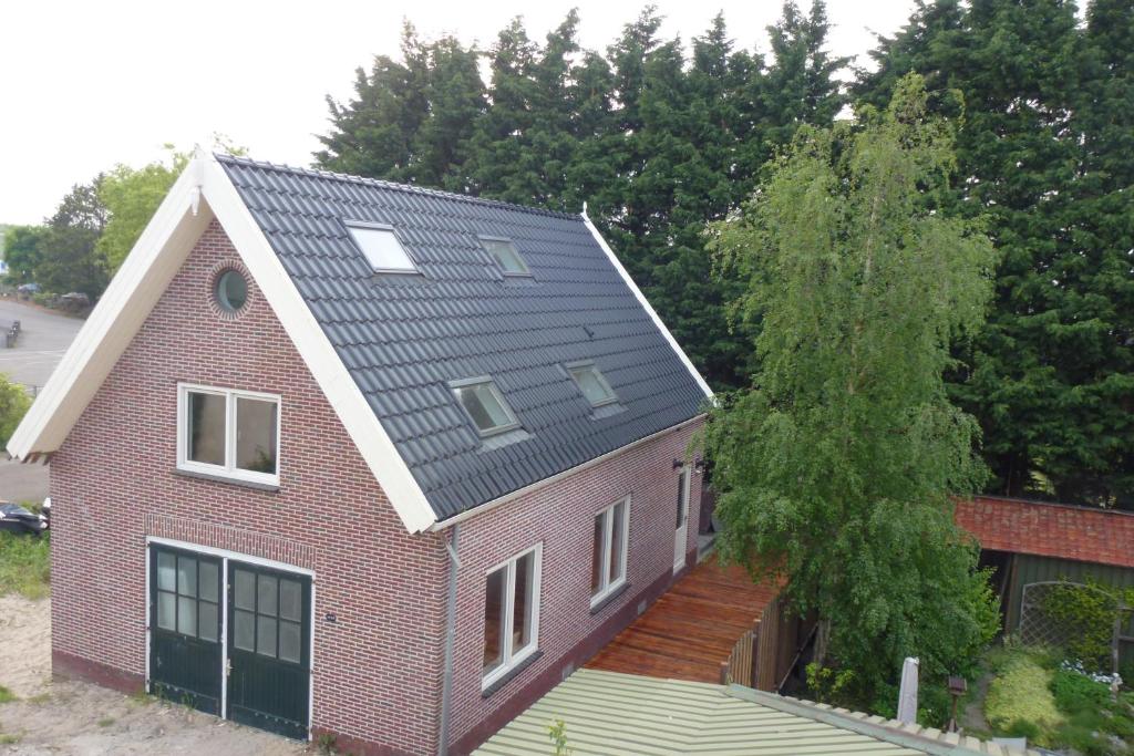 una casa de ladrillo rojo con techo negro en Schiphol Apartments, en Aalsmeer
