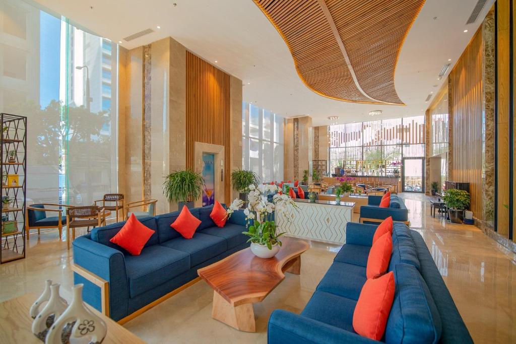 A bright, spacious lobby lounge with deep blue sofas and red cushions.