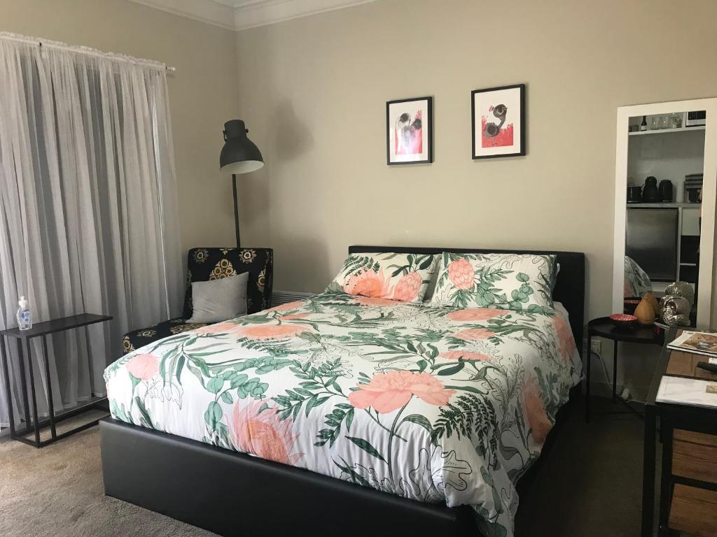 um quarto com uma cama com um edredão floral em L'École Private Studio-Apartment by My Lodgingfy em Moorabbin