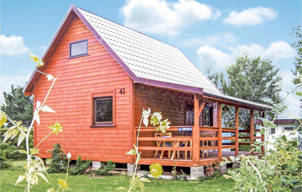 a large red cabin with a gambrel roof at 2 Bedroom Cozy Home In Leba-nowecin in Łeba