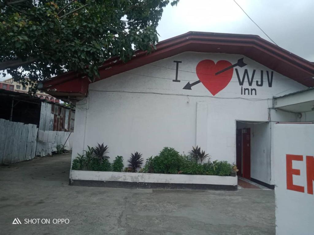 a white building with a heart painted on it at WJV INN Humay-humay in Gun-ob