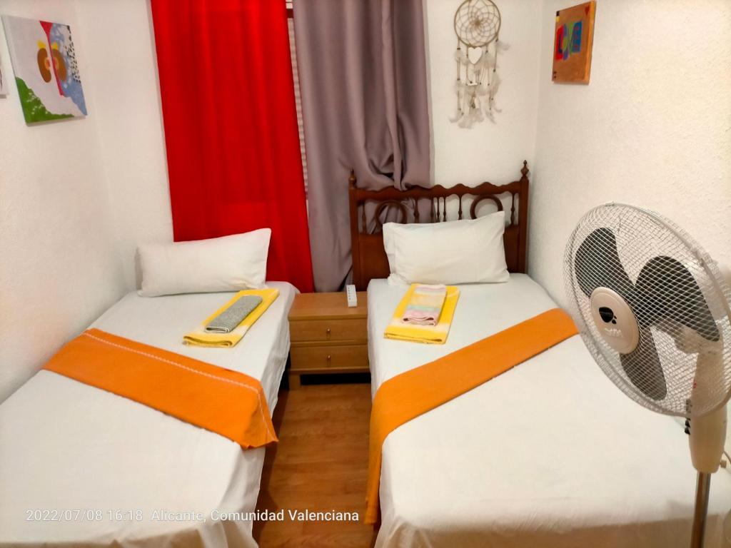 2 łóżka pojedyncze w pokoju z wentylatorem w obiekcie Аlicante w Alicante
