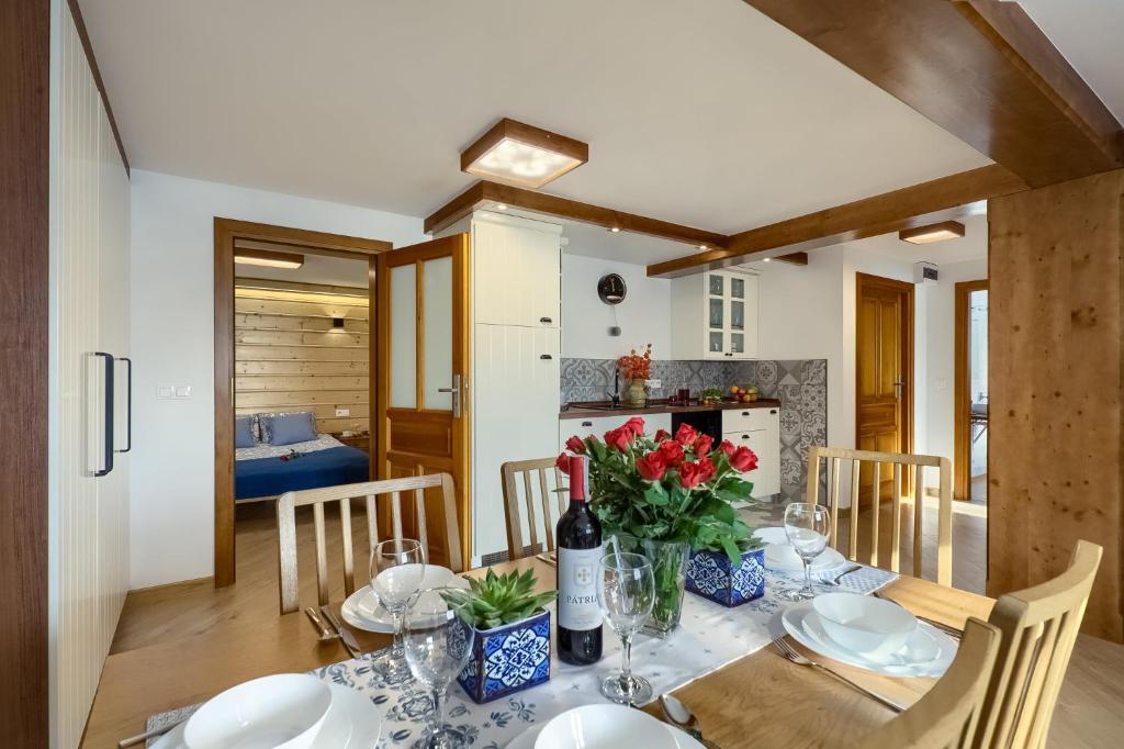 uma sala de jantar com uma mesa e uma garrafa de vinho em Apartament Uroczy Zakątek em Tylicz