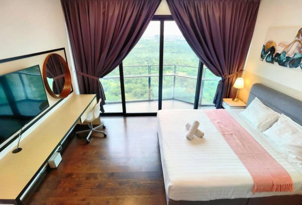Schlafzimmer mit einem Bett, einem Schreibtisch und einem Balkon in der Unterkunft C2518 Almas Suite seaview Muji100mbpsNetflix by STAY in Nusajaya