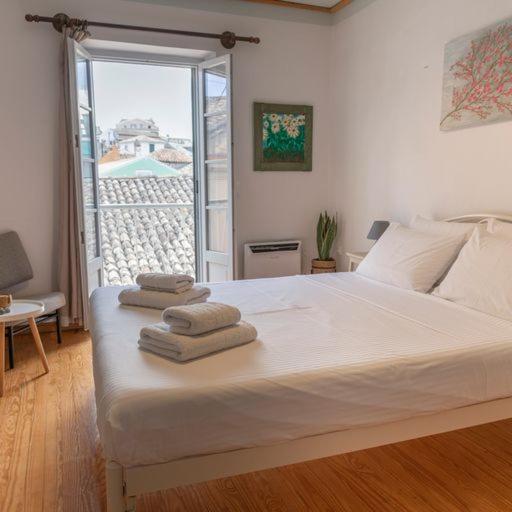ein Schlafzimmer mit einem großen Bett mit Handtüchern darauf in der Unterkunft Nasos Corfu Town Apartment in Korfu-Stadt