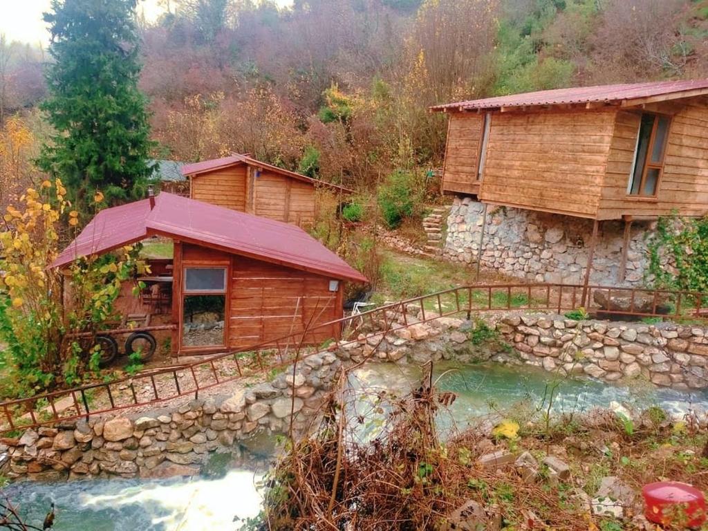 uma cabana de madeira com uma ponte ao lado de um rio em Kure Dag Evi em Ulus