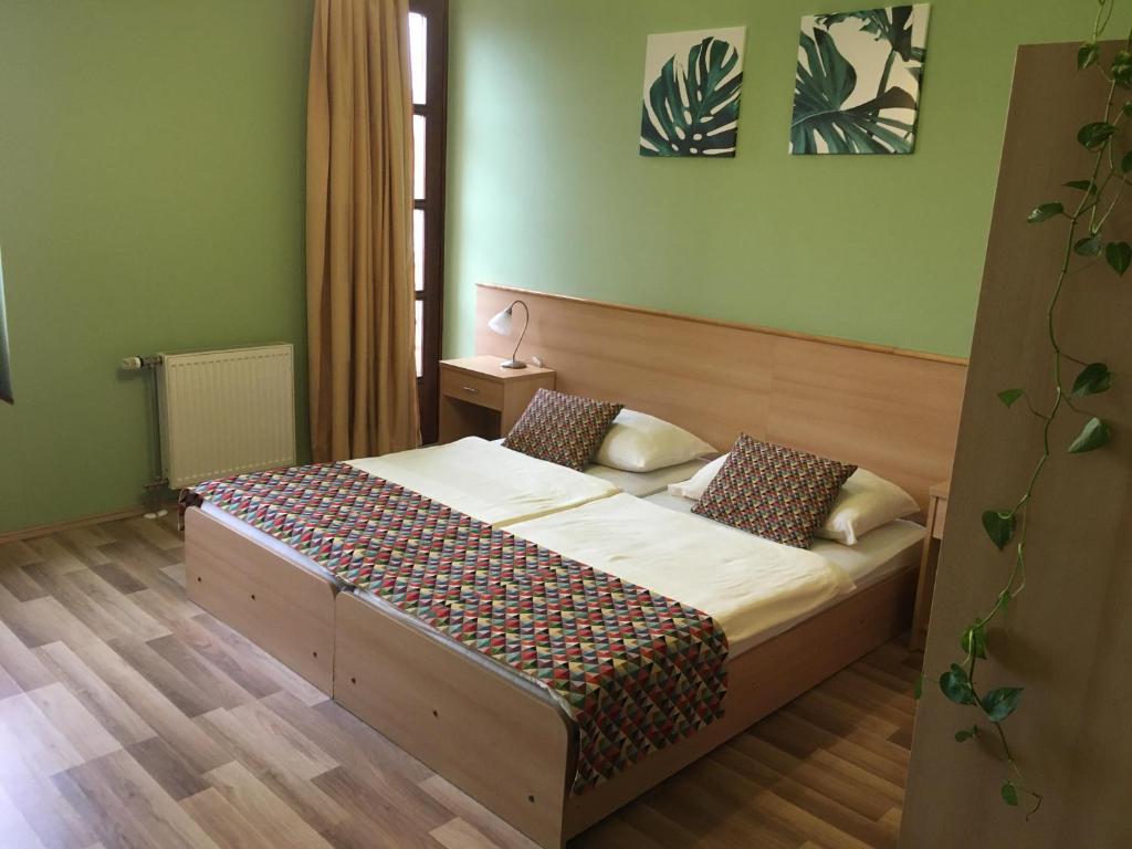 ein Schlafzimmer mit einem Bett in einem Zimmer in der Unterkunft A Bárány in Kaposvár