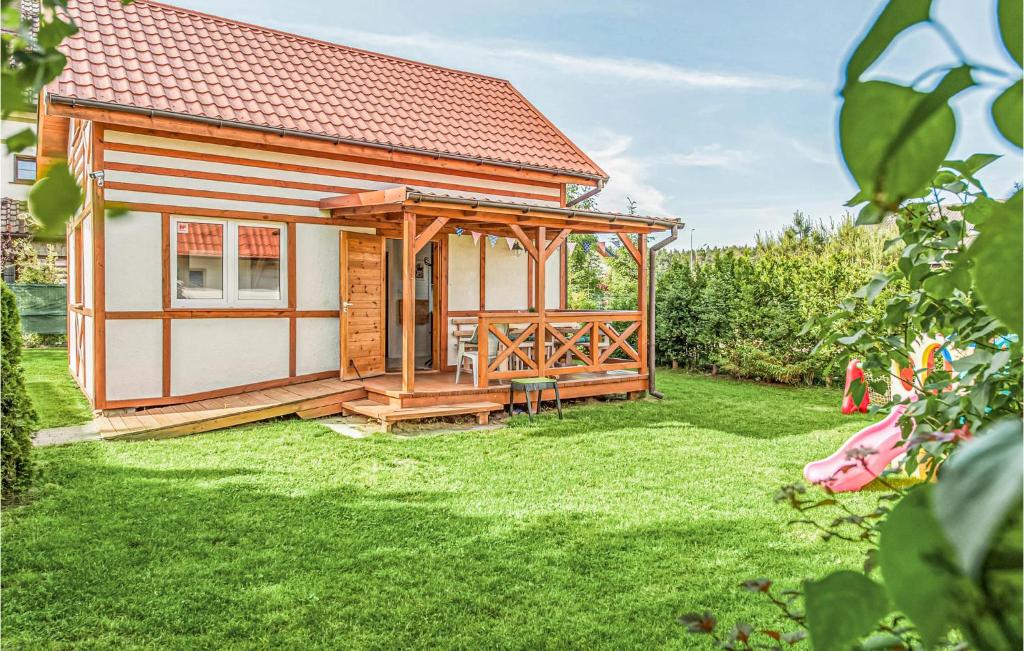 a small cabin with a deck in a yard at Amazing Home In Ustka-przewloka With 3 Bedrooms And Wifi in Ustka