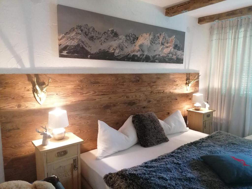 sypialnia z łóżkiem i drewnianą ścianą w obiekcie Kitzdesign in Kirchberg w mieście Kirchberg in Tirol